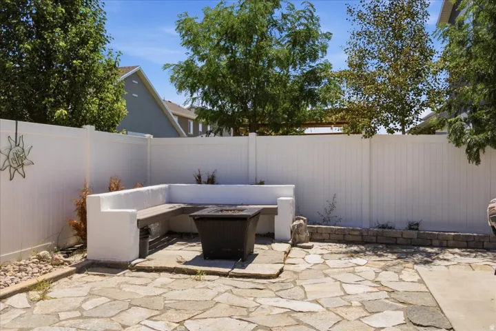 Private backyard featuring a stone patio and white privacy fencing