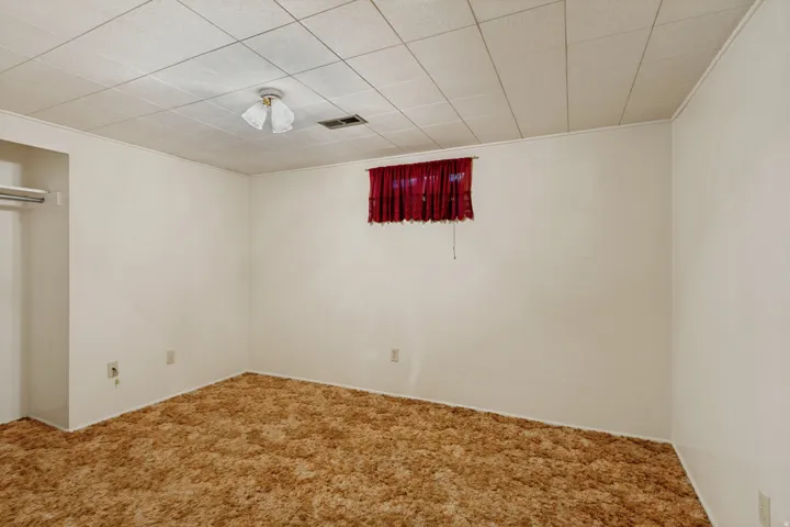 Drop ceiling with recessed lighting, wall-to-wall carpeting, and painted walls