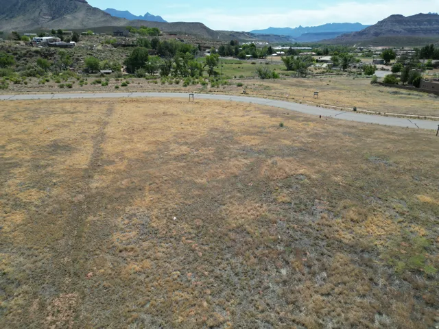 Expansive land parcel with natural vegetation, featuring a paved road