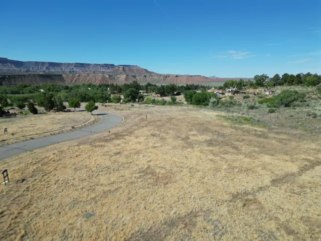 Expansive undeveloped land featuring a paved road and distant mountain range