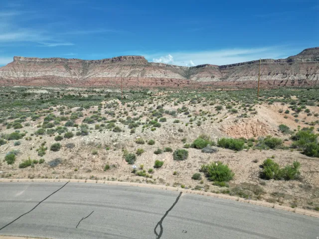 Expansive desert landscape featuring natural rock formations and a paved road