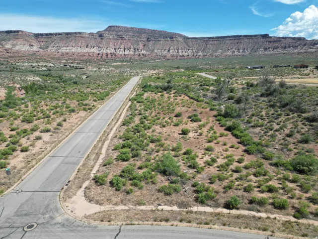 Paved road access, mountainous terrain, desert vegetation, and clear skies