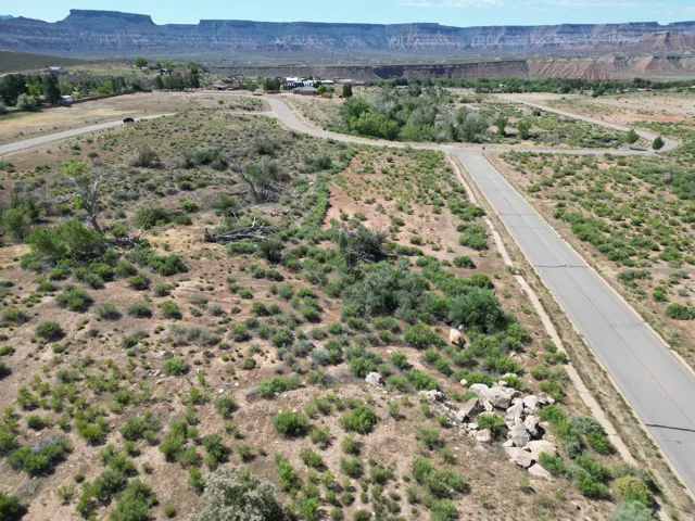 Desert landscape featuring paved roads and distant mesa formations