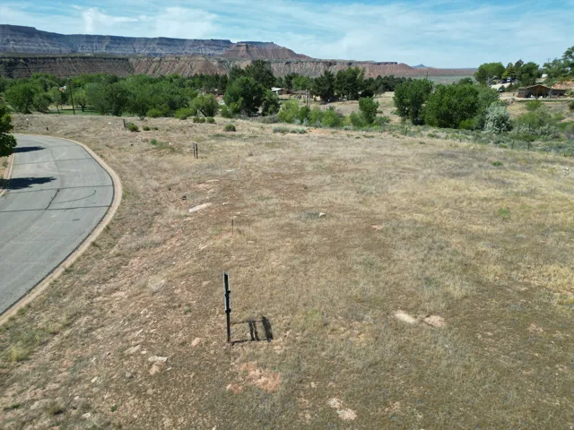 Paved road frontage, natural landscaping, and distant mountain backdrop