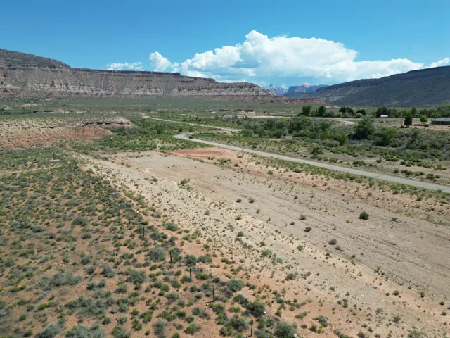 Paved road through a desert landscape with distant mountains