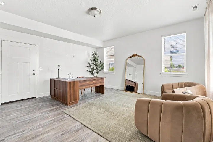Wood-finish flooring throughout, white interior walls, and multiple windows with blinds