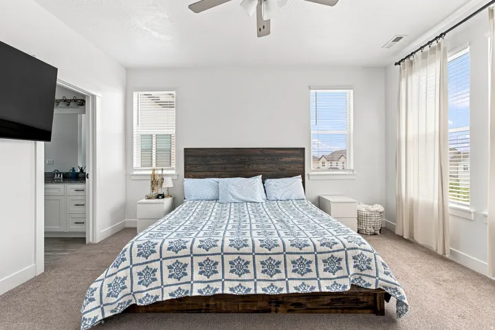 Spacious bedroom with light-colored carpeting and bright white walls