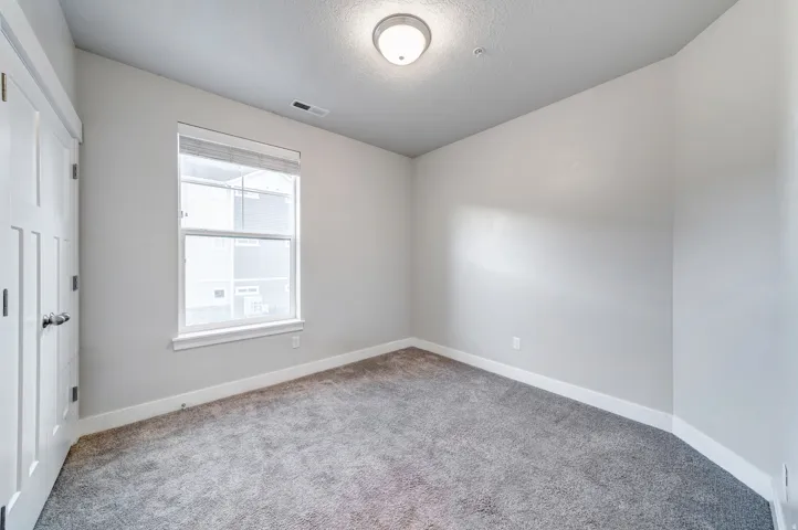Neutral wall finishes, recessed window, paneled interior door, and overhead flush-mount lighting