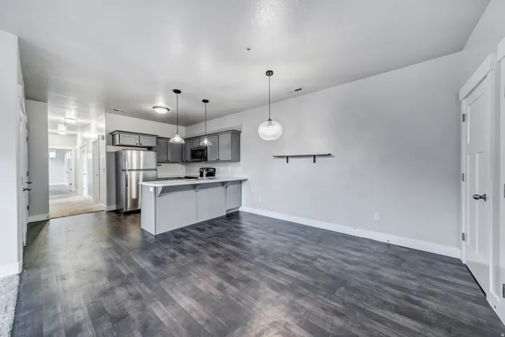 Kitchen featuring stainless steel appliances, grey cabinetry, white countertops, and a white tile backsplash