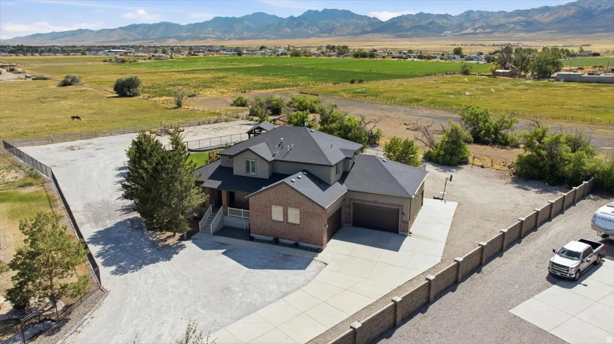 Expansive property with a multi-story residence featuring brick and siding exterior, a multi-car garage, and a concrete driveway