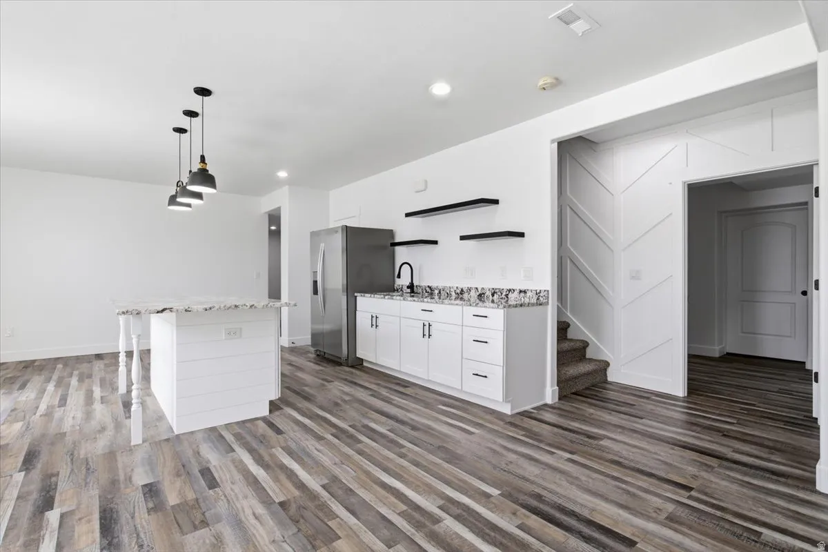 Wood-finish flooring throughout, complemented by a white shiplap island with a countertop