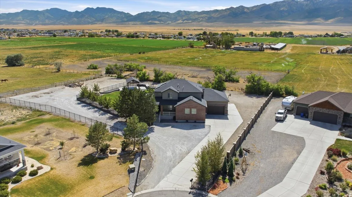 Two-story residence with a brick and siding exterior, concrete driveway, attached two-car garage, and a gated perimeter