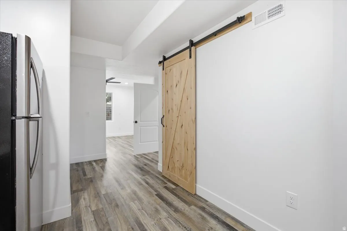 Wood-finish flooring throughout, with a natural wood barn door on a black metal track
