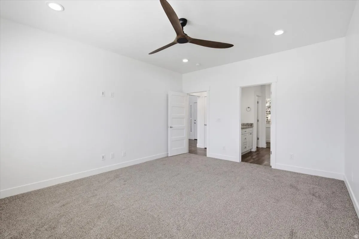 Recessed lighting, ceiling fan with dark wood-finish blades, white walls, and gray carpeted flooring