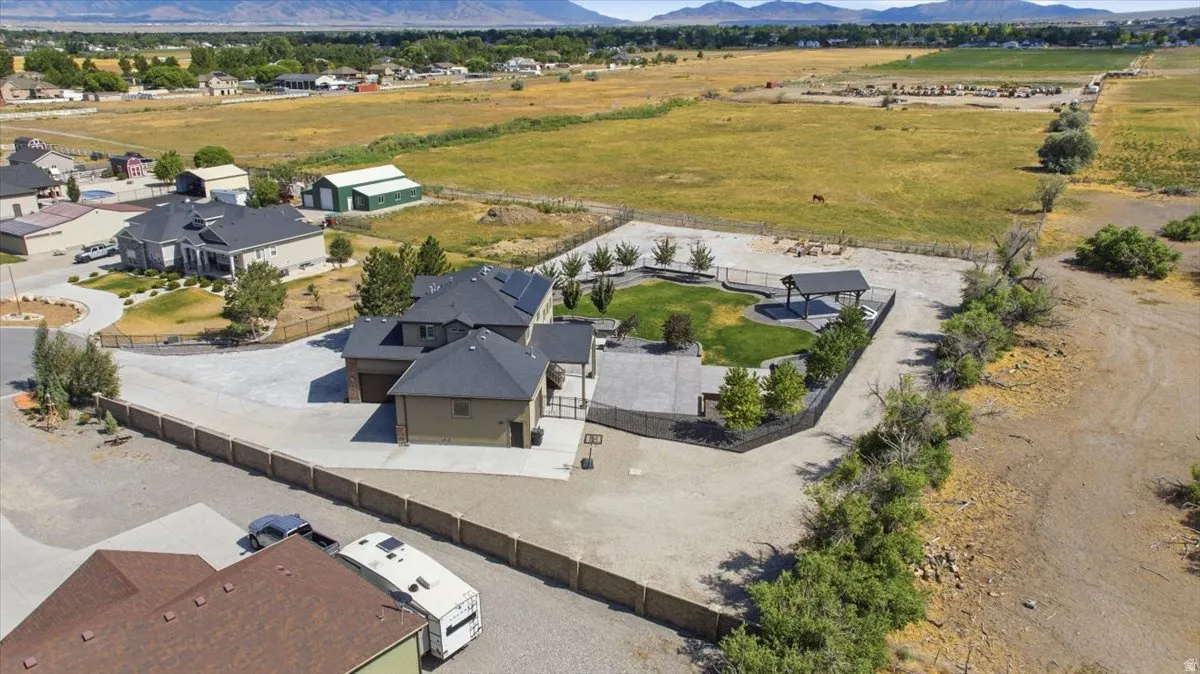 Expansive property featuring a multi-level residence, detached garage structure, paved driveway, and established landscaping