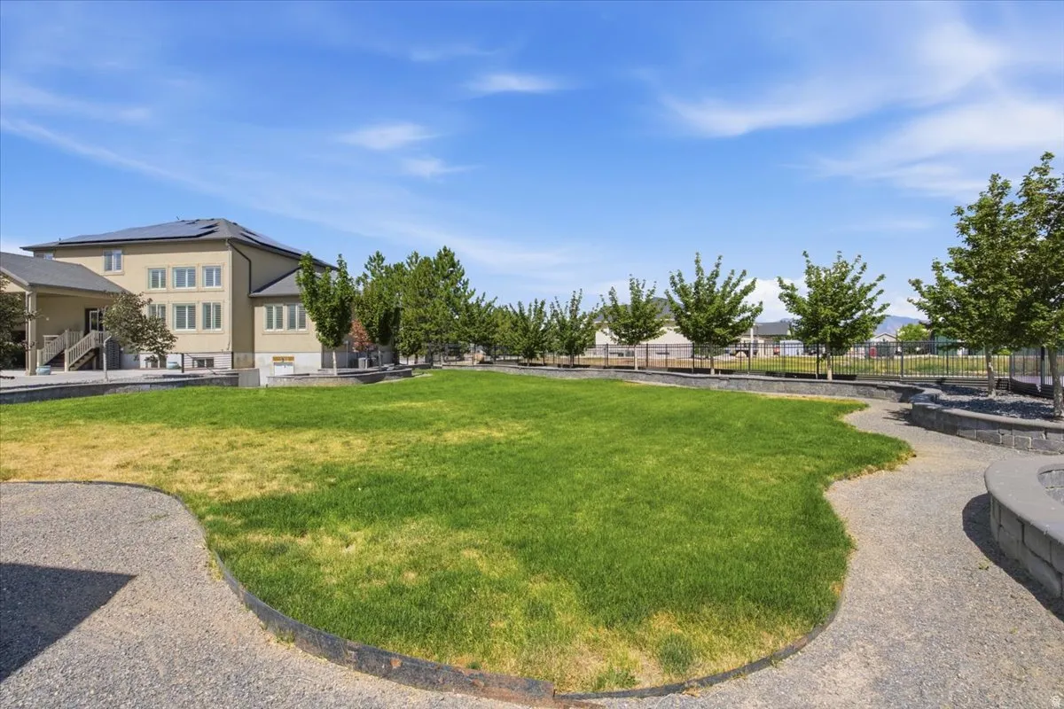 Expansive lawn area surrounded by gravel pathways and mature trees