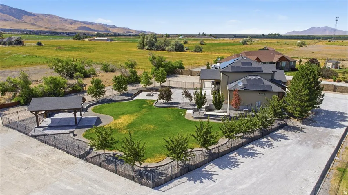 Spacious property featuring a large green lawn, covered outdoor structure, and solar panels on the roof