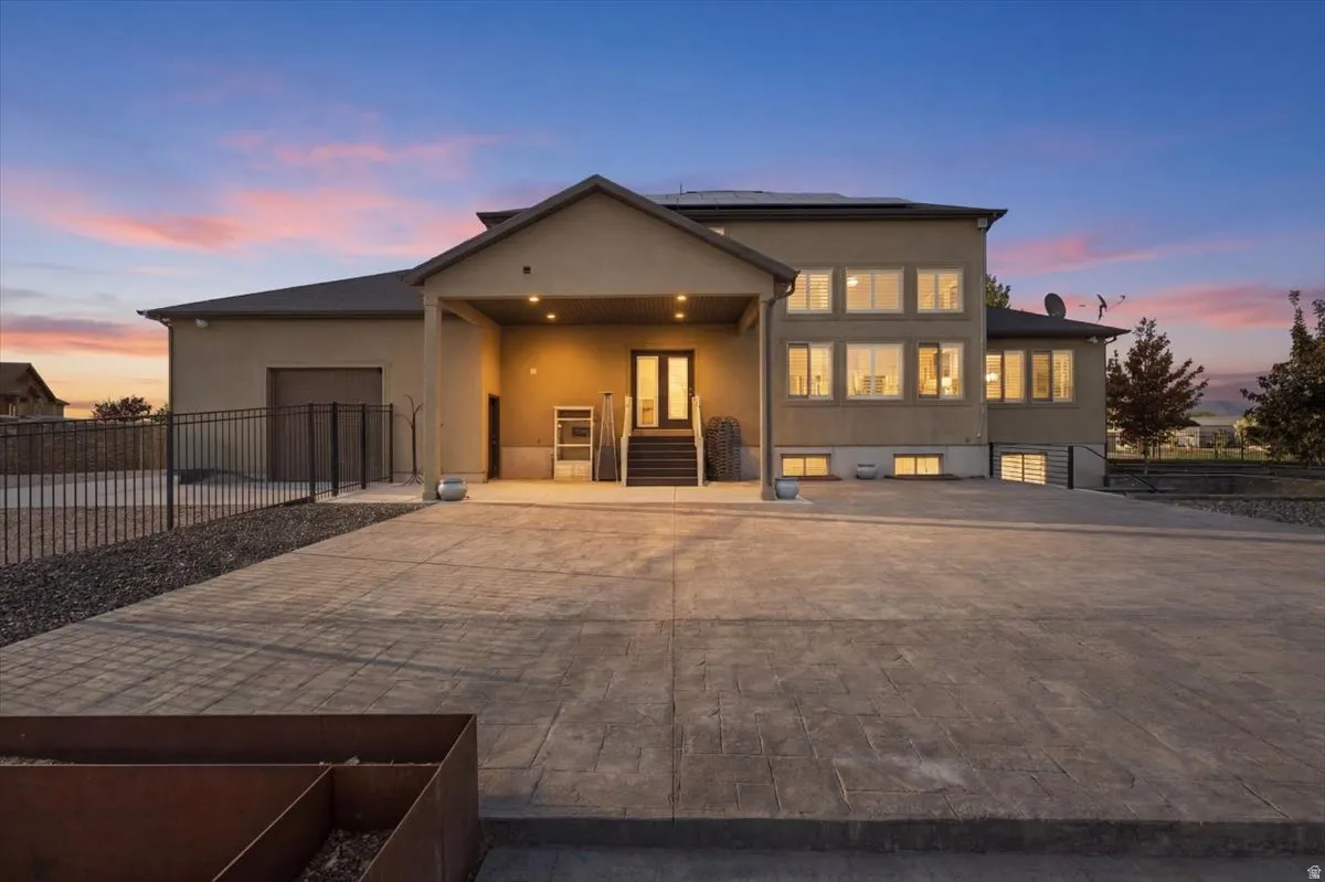 Stucco exterior with multiple windows, covered entry, and attached garage