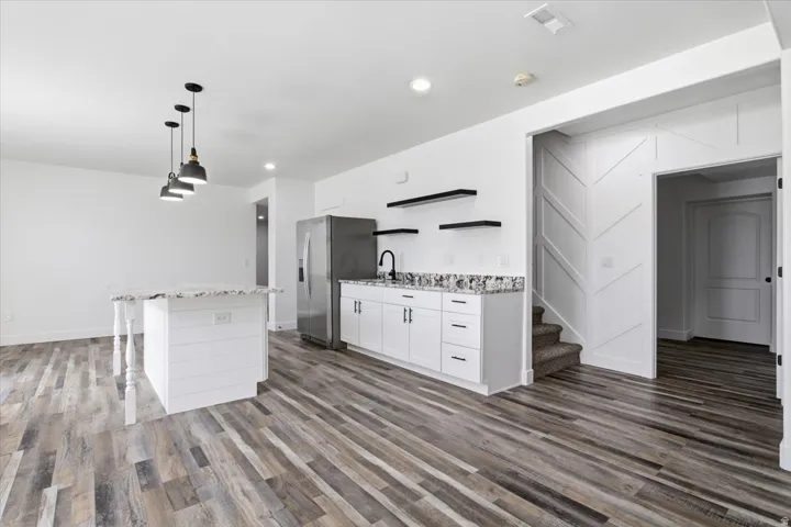 Wood-finish flooring throughout, complemented by a white shiplap island with a countertop