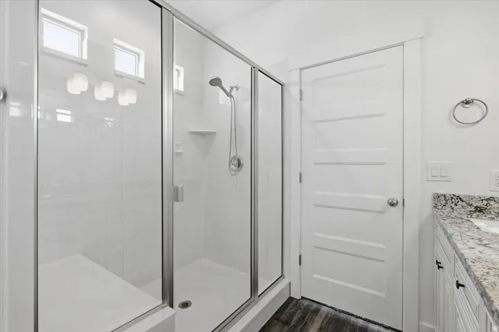 Glass-enclosed shower with a built-in bench, shower niche, and small transom windows