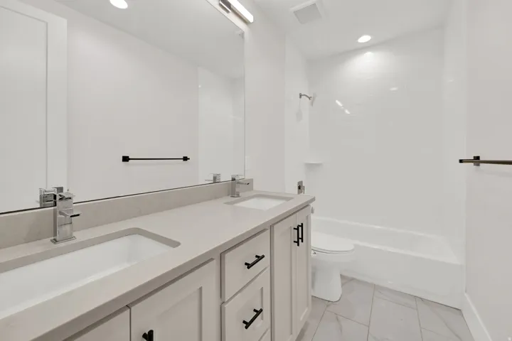 Dual vanity with undermount sinks, chrome faucets, and light-toned countertops