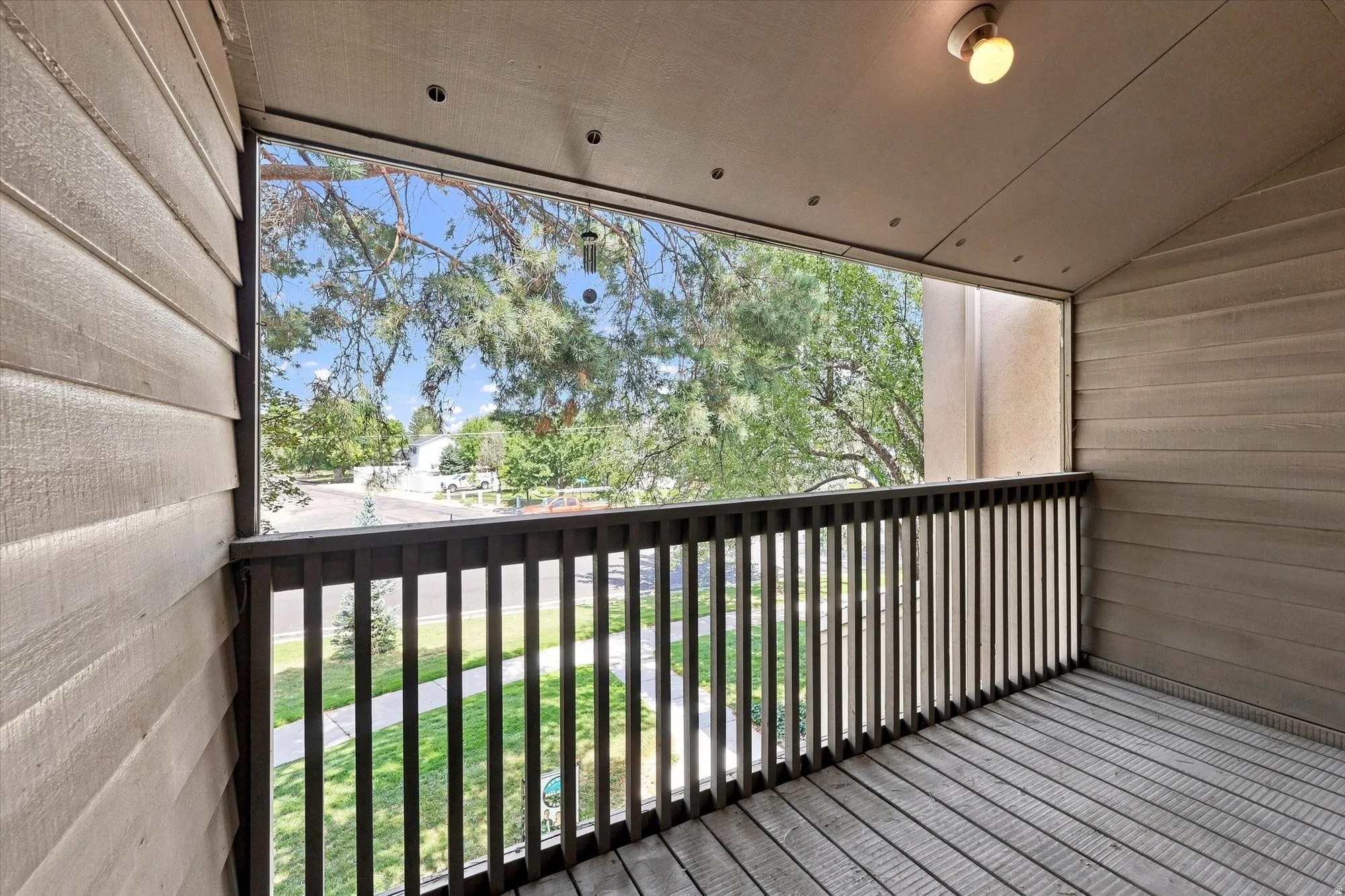 Exterior balcony featuring wood-finish decking, dark wood railing, and shiplap siding