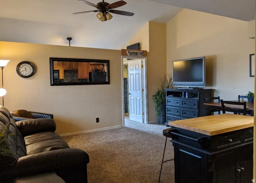 Vaulted ceilings, a ceiling fan with integrated lighting, and a neutral wall color