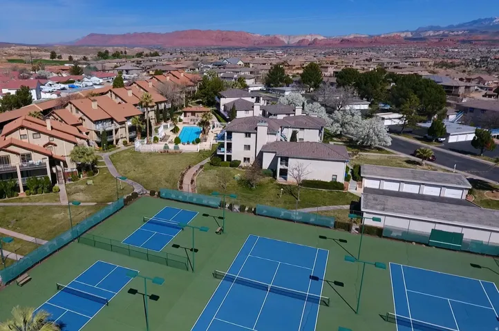 Multiple tennis courts with blue playing surfaces
