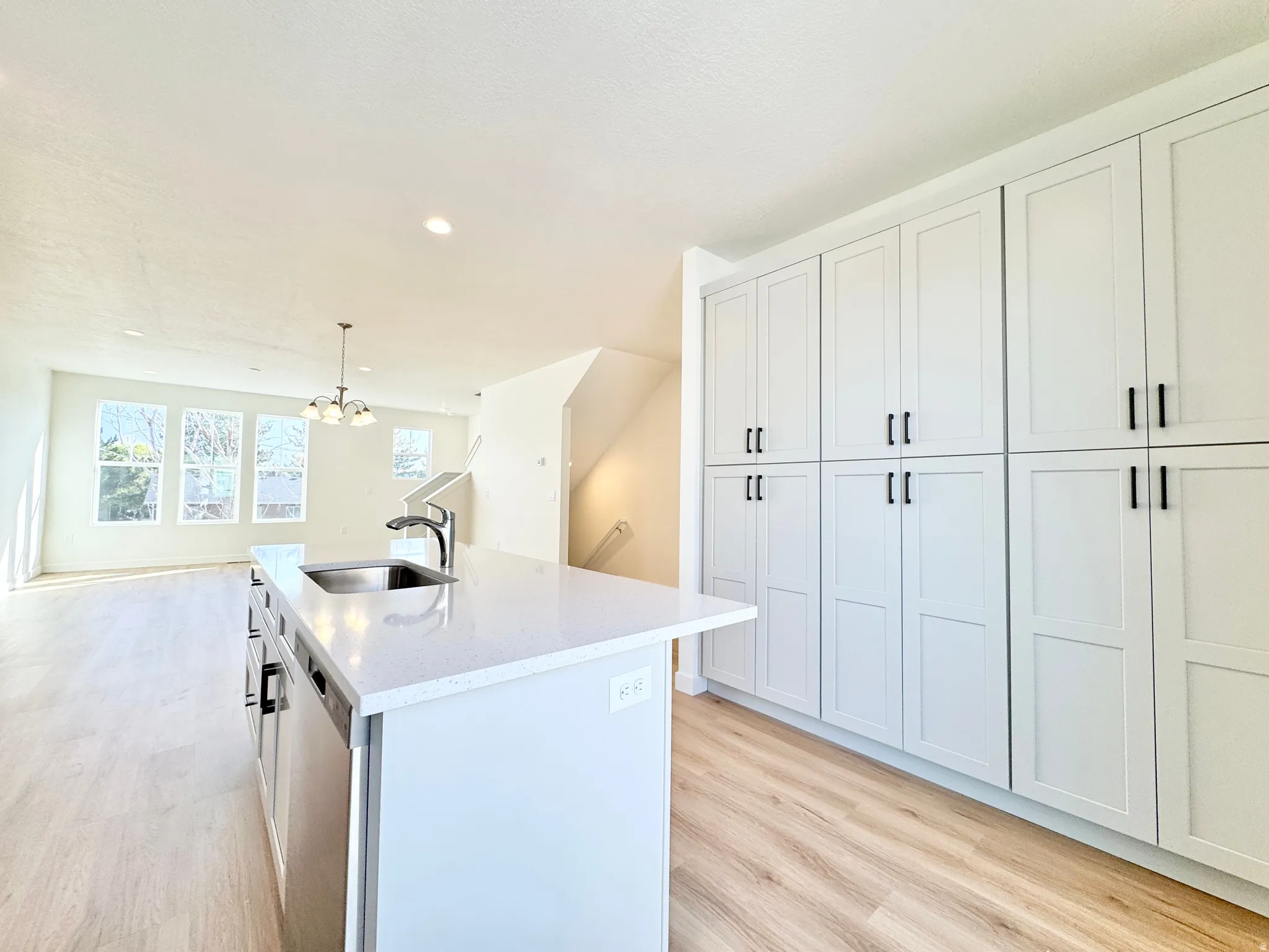 Kitchen island featuring an undermount sink and a built-in dishwasher