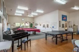Spacious recreation room featuring wood-finish flooring, recessed lighting, and large windows