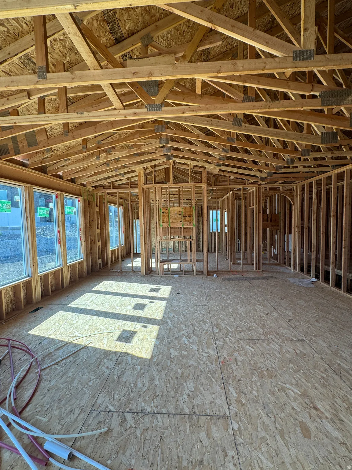 Open-concept design with extensive framing, multiple windows, and exposed ceiling trusses