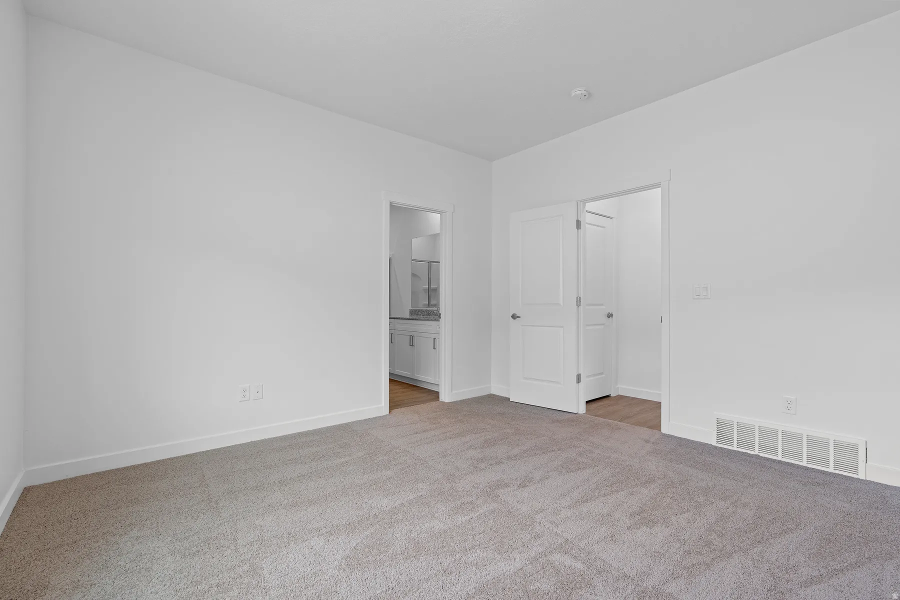 Recessed lighting, light-toned walls, and carpet flooring