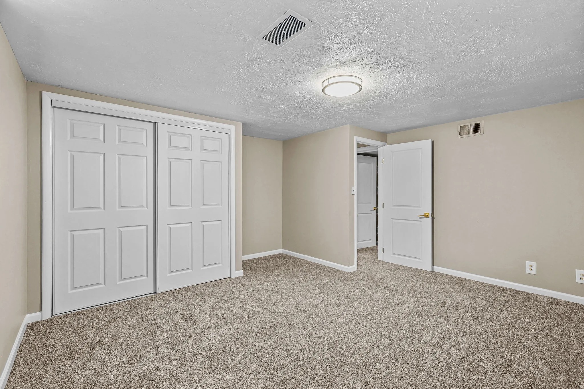 Plush carpet flooring, neutral paint palette, white trim, and a flush-mount ceiling light fixture