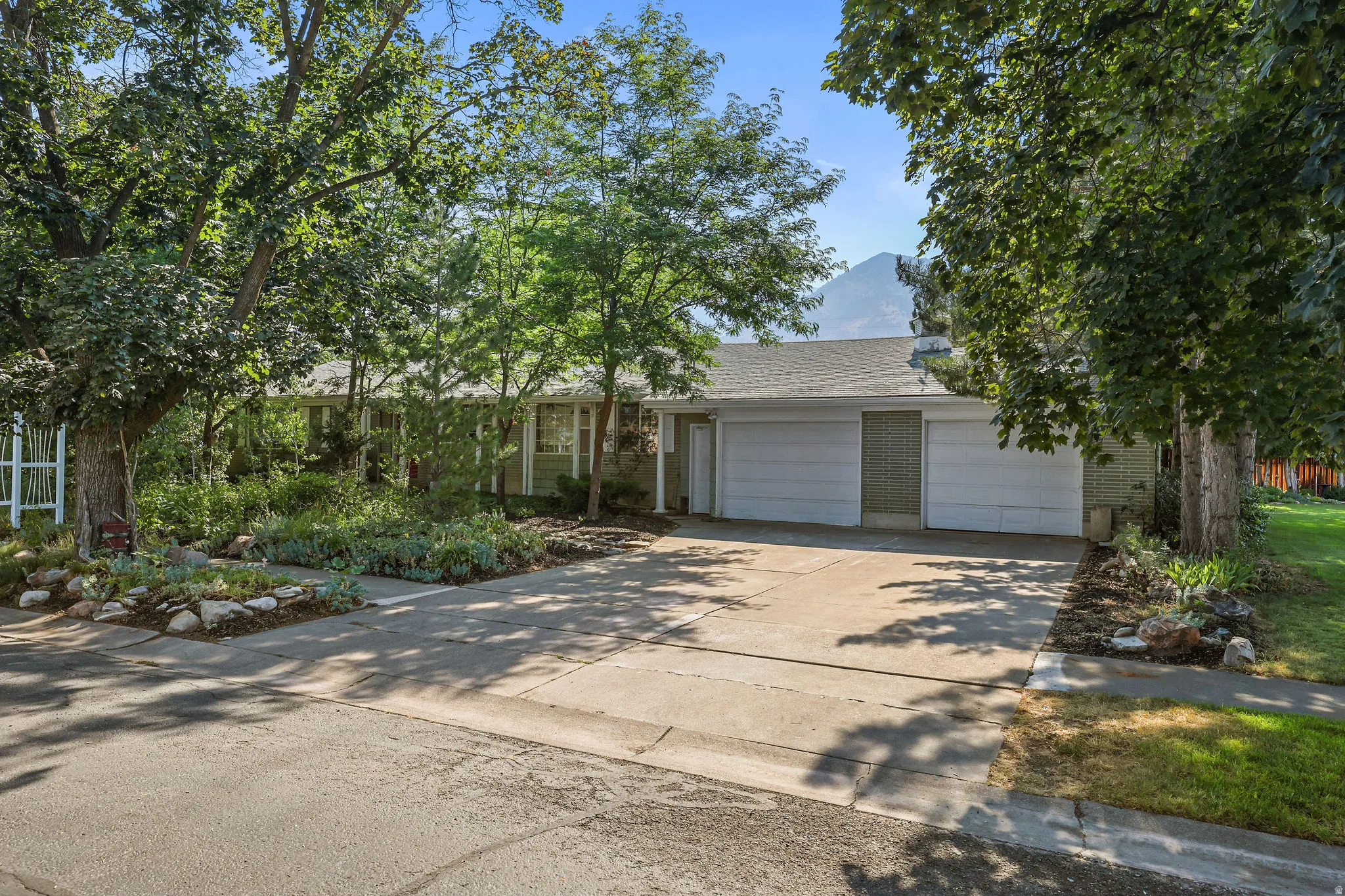 Single-story exterior with a double-width driveway, an attached two-car garage, and established landscaping