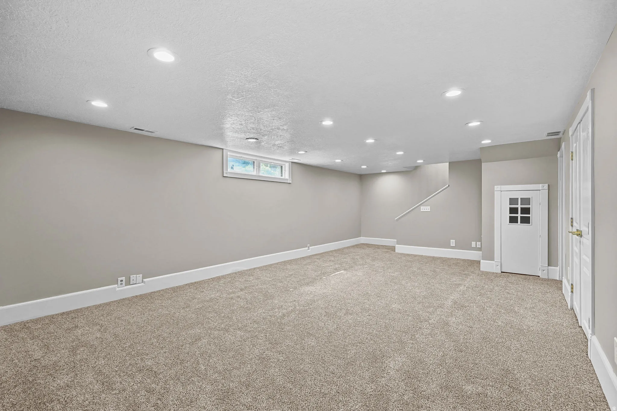 Expansive room featuring recessed lighting, plush carpeting, light gray walls, and white trim