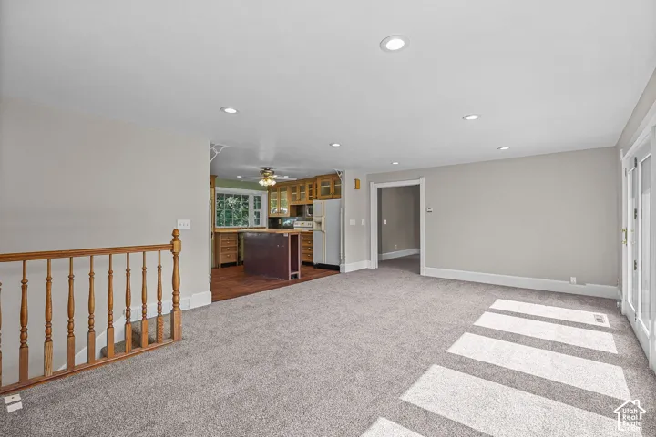 Spacious upper-level room featuring gleaming wood-finish flooring, recessed ceiling lighting, and abundant natural light from expansive windows