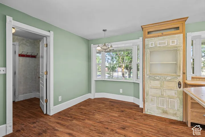 Wood-finish flooring, bay windows, built-in display cabinet, and a chandelier