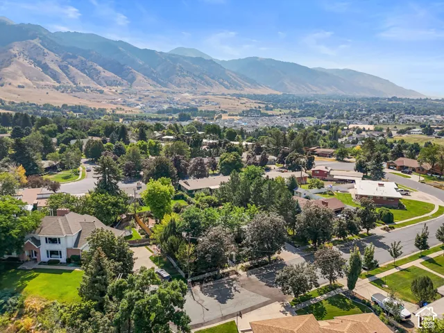 Expansive mountainous backdrop over a residential community with mature trees and established homes
