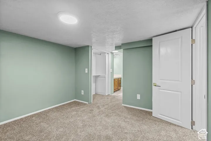 Recessed ceiling lighting, textured carpet flooring, and white trim