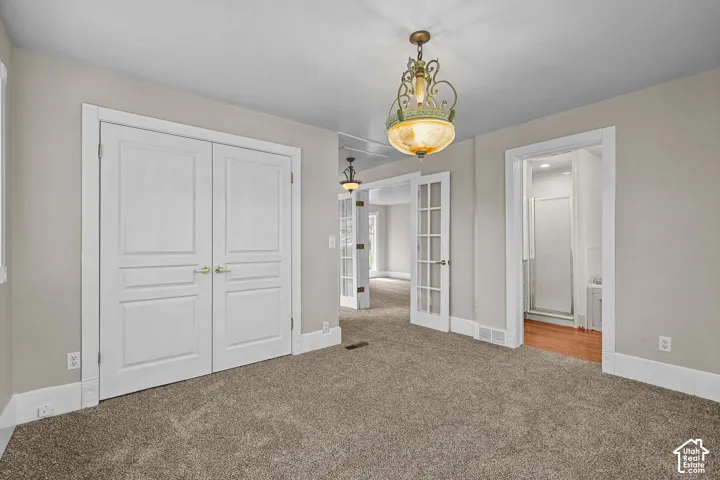 Recessed panel double doors, glass-paneled French doors, and a decorative pendant light fixture