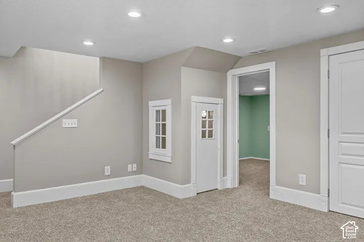 Recessed lighting illuminates a carpeted floor