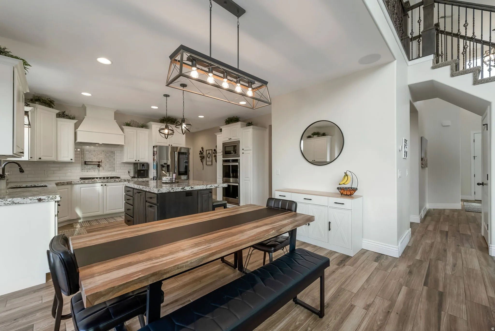 Modern kitchen with white cabinetry, a dark-toned island, and built-in stainless steel appliances