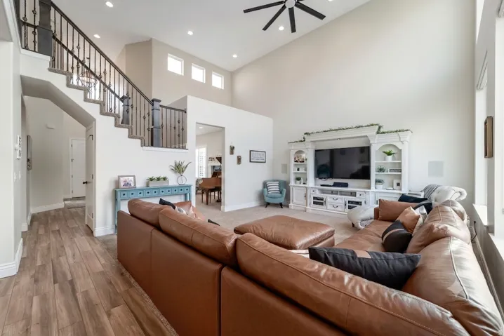 Open-concept living area featuring soaring vaulted ceilings with skylights, a ceiling fan, and recessed lighting