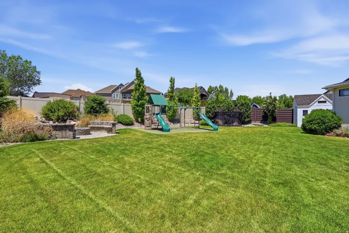 Expansive lawn area with a stone-faced retaining wall and integrated stone bench seating