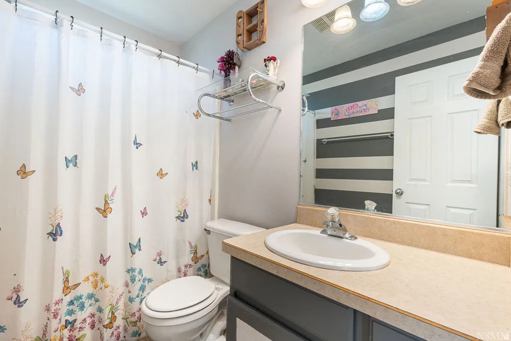 Vanity with integrated sink, chrome faucet, and expansive mirror