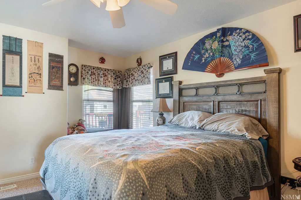 Wall-to-wall carpeting and a ceiling fan with integrated lighting