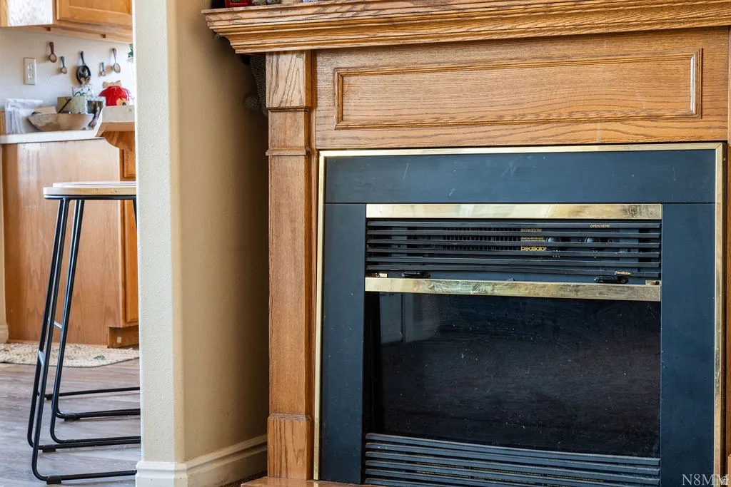 Elegant wood-trimmed fireplace surround featuring a dark blue accent wall and horizontal slat detailing, anchoring the living space with classic architectural charm and a substantial built-in hearth