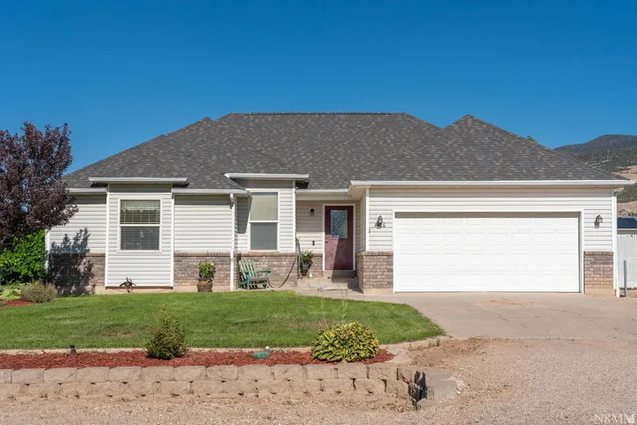 Charming ranch-style residence featuring a composite shingle roof, brick and vinyl siding exterior, and a two-car attached garage