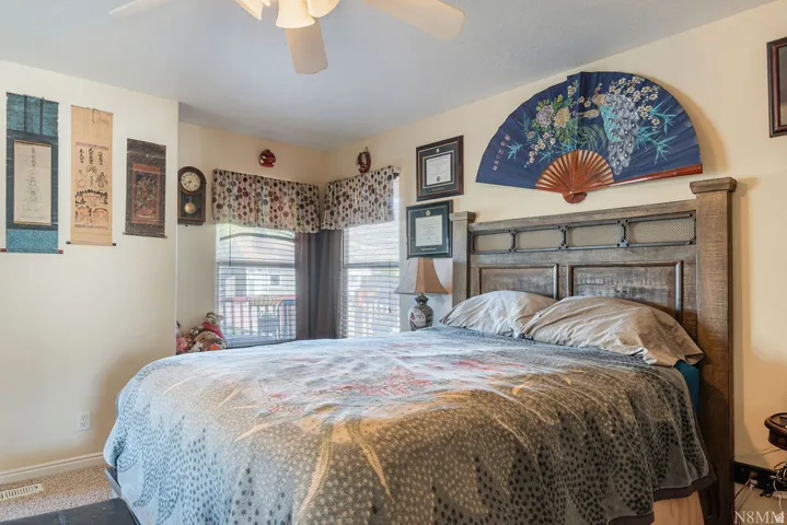 Wall-to-wall carpeting and a ceiling fan with integrated lighting