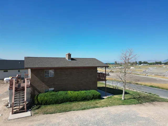 Solid brick construction with a pitched roof and chimney, situated on expansive grounds